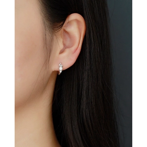 Close-up of s925 silver hoop earring with clear teardrop cubic zirconia on a model