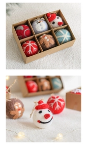 Detail of wool felt Christmas ornaments including gingerbread man and snowman in a gift box