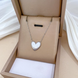 Close-up of heart shell pendant necklace in a luxury beige jewelry gift box