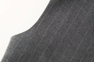 Gros plan sur la texture du tissu sergé gris foncé pour ensembles élégants deux pièces