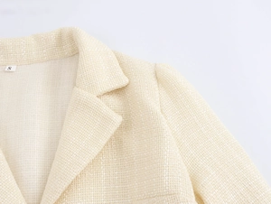 Dettaglio ravvicinato del colletto del blazer in tweed avorio e trama del tessuto