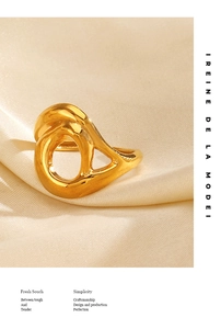 Gros plan détaillé d'une bague géométrique irrégulière dorée sur de la soie beige