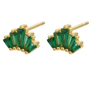 Detail view of gold-plated brass fan earrings with green baguette-cut cubic zirconia