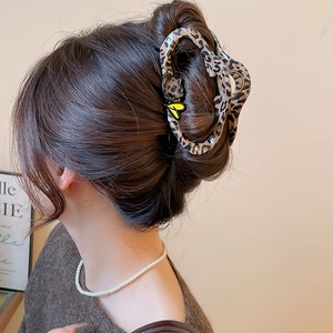 Leopard print shark hair clip with heart detail shown on model back of head