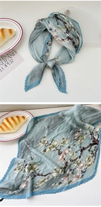 Macro detail of pleated floral scarf in grey-blue with exquisite accordion texture