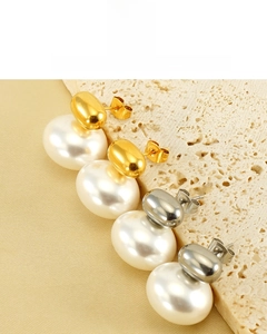 Detailed macro view of 18K vacuum plated pearl stud earrings with a glossy metal finish