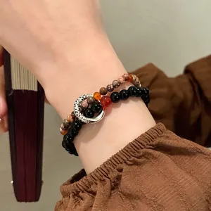 Detail of double-layer beaded bracelet with obsidian, jasper stones and vintage silver ring