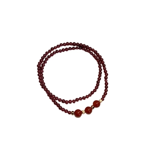 Garnet and red agate bead bracelet with golden spacers on a clean white background