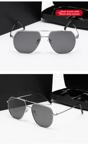 Detalle de gafas de sol aviador de metal plateado con lentes grises y puente doble