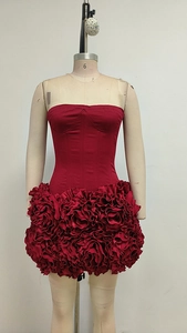 Détail de la robe bulle rouge avec texture plissée en roses 3D et éclat satiné chic