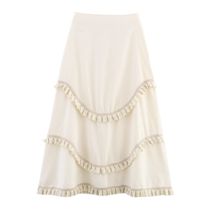 Detail of cream white maxi skirt with three-layer bohemian fringe tassels in A-line cut