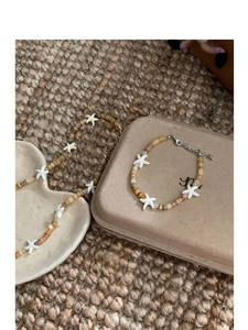 Detail view of starfish charms and shell beads on necklace and bracelet set