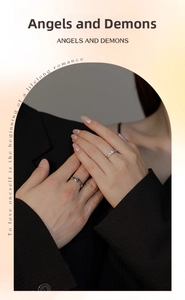 Close-up of angel and demon couple rings showing wings design and inlaid center stone