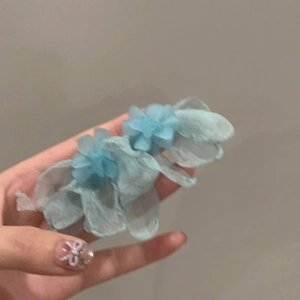 Detailed view of handmade light blue tulle flower clip with layered soft petals
