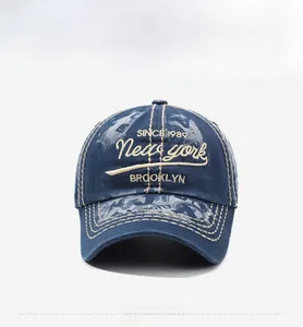 Close-up of vintage navy denim baseball cap featuring white 3D embroidery and contrast stitching