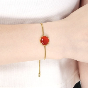 Détail du bracelet chaîne serpent dorée ajustable avec un pendentif en pierre rouge