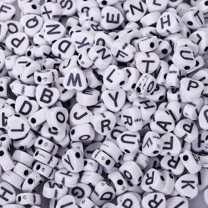 Close-up of heart-shaped acrylic alphabet beads with black letters for DIY jewelry making