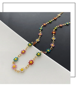 Close-up of colorful daisy beads on gold chain with vibrant floral enamel pendants