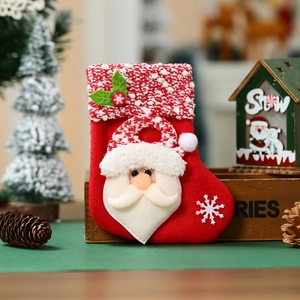 Detail of red Christmas stocking with 3D Santa Claus applique and white snowflake embroidery