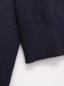 Dettaglio di polo in maglia blu scuro con polsini a costine e trama di alta qualità