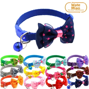 Close-up of colorful nylon pet collars with polka dot bows and matching metal bells