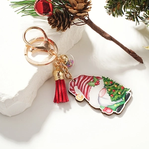 Christmas gnome wooden keychain with red tassel, bell, and sequin ball on stone decor