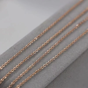 Set of four rose gold stainless steel cable chain necklaces on a grey velvet display