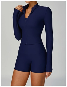 Detail of ribbed dark blue yoga set featuring long sleeve zip top and high waist shorts