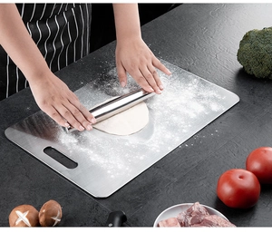 Chef rolling dough on a premium 316 stainless steel cutting board with rolling pin