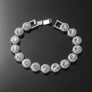 Silver Cuban link bracelet with round pavé crystals laid on a black reflective surface