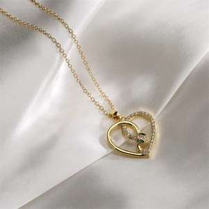 Gold necklace with heart pendant and zircon snake detail featuring green eyes