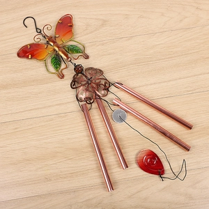Detail of metal butterfly wind chime with glass painting, copper tubes, and red pendant charm
