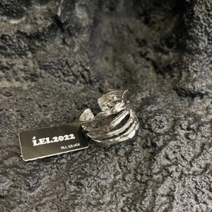 Irregular four-layer silver open ring with lava texture on dark stone background