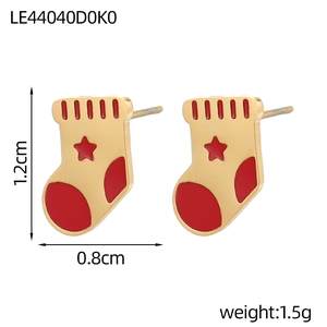 Détail des boucles d'oreilles chaussette de Noël rouge avec motif étoile dorée