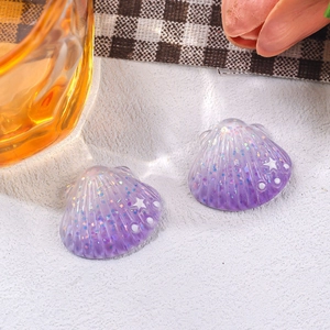 Close-up of small purple glitter resin shells with star patterns for DIY accessories