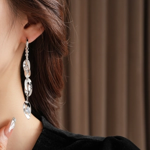 Vue macro de boucles d'oreilles pendantes en argent avec zircons et trois gouttes ovales