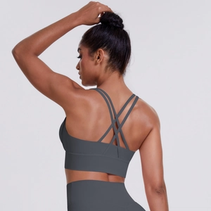 Detail of cross-back straps on dark grey sports bra with supportive wide elasticated band