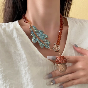 Vintage necklace with crystal leaf and acorn pendant on amber beads with gold OT buckle