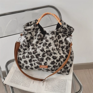 Détail du sac en peluche léopard avec poignées à damier et bandoulière réglable en nylon