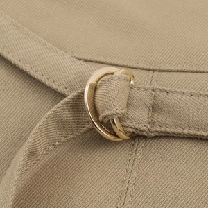 Détail de la ceinture en sergé kaki avec deux boucles métalliques dorées en forme de D