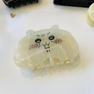 Detail of cute cat acetate hair claw with pearlescent finish and cartoon face design