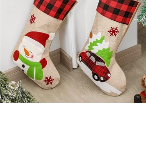 Detail of burlap Christmas stockings featuring festive snowman and red car appliques