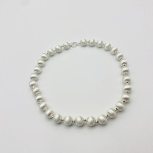Détail du collier à billes argentées avec texture brossée et fermoir en T élégant