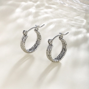 Detailed view of silver chain texture hoop earrings with elegant water ripple shadows