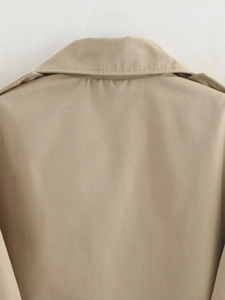 Close-up detail of khaki trench coat collar and twill fabric texture with stitching