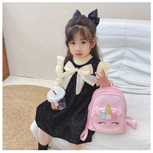 Toddler girl wearing pink unicorn backpack with sparkling glitter sequins and heart pattern