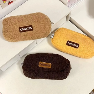 Detailed view of three plush cookie-themed pencil cases in khaki, yellow, and coffee brown