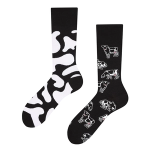 Detail showing asymmetric knit socks with cow print and pixelated cow pattern