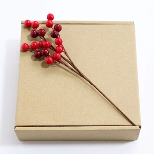 Artificial red holly berry branch on kraft gift box for Christmas and holiday decoration