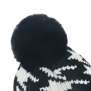 Classic black and white houndstooth knit beanie featuring a large fluffy pom-pom